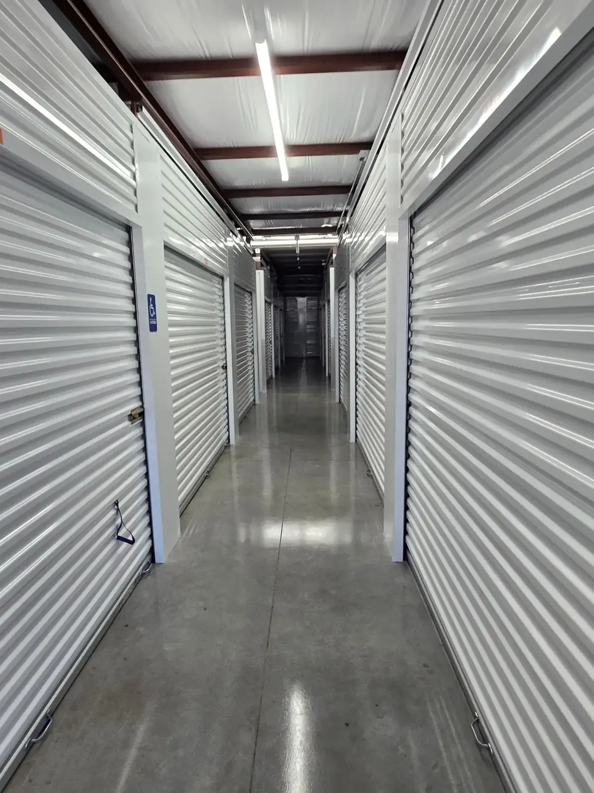 Interior hallway of a self storage facility with white doors.