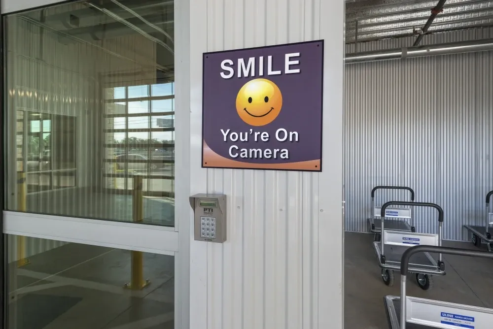 "Smile your on camera" sign at ATX Self Storage.