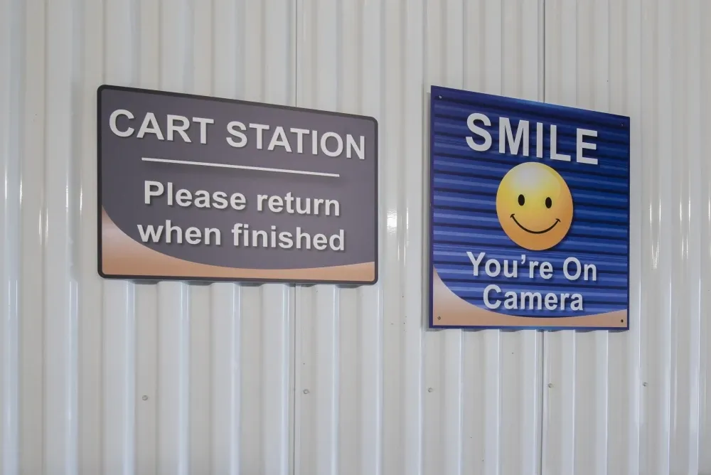Cart station and "smile you're on camera" signage at EaDo Storage.
