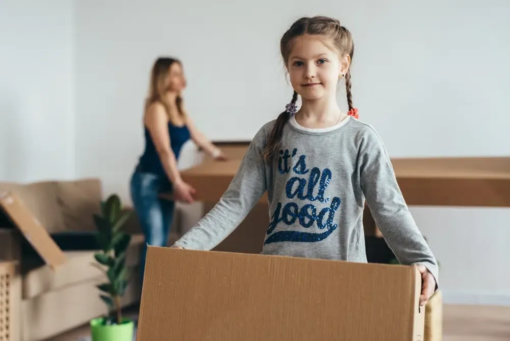 Young girl holding moving box