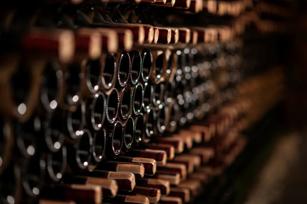 Rows of wine bottles kept in a dark storage space.