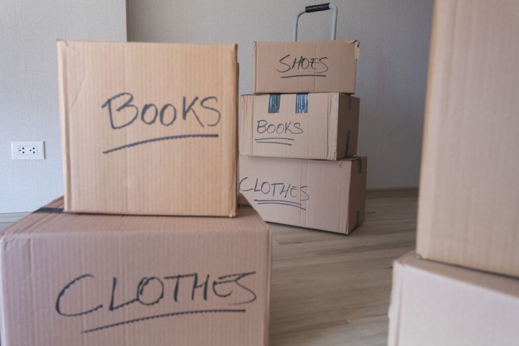 Various cardboard boxes labeled as “books,” “clothes,” and “shoes.”