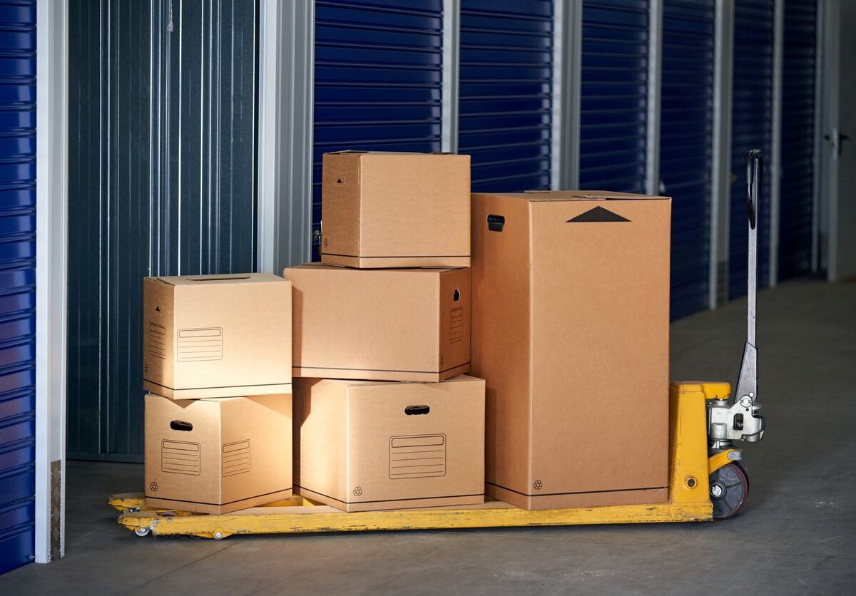 Stacks of multiple cardboard boxes on a trolley about to be stored in a self-storage unit.