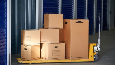 Stacks of multiple cardboard boxes on a trolley about to be stored in a self-storage unit.