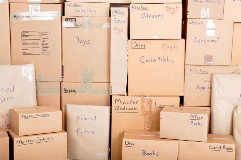 Stacks of labeled cardboard boxes, including boxes labeled “books,” “toys,” “collectibles,” and more.